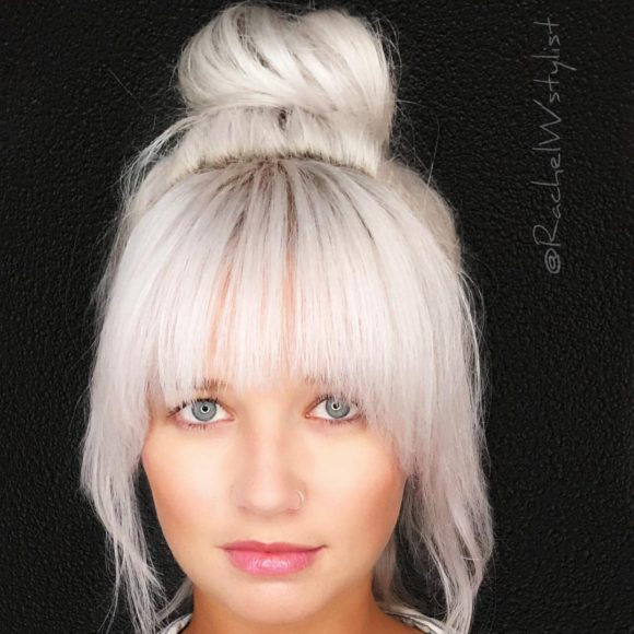 Large Messy Top Bun with Full Face Framing Fringe and Platinum Blonde Hair Color