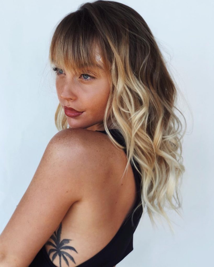 Layered and Banged Cut with Messy Boho Chic Waves and Sun Kissed Blonde Balayage Medium Length Summer Hairstyle