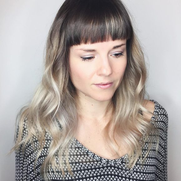 Polished Wavy Layered Cut with Blunt Baby Bangs and Cool Blonde Color Melt