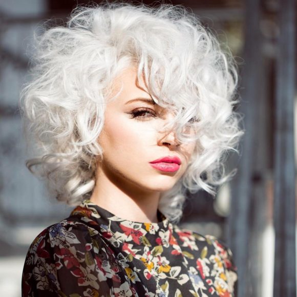 Sexy Platinum Mod Bob with Allover Messy Curly Texture and Long Side Swept Curly Bangs Medium Length Retro Fall Hairstyle