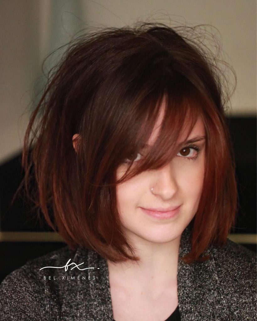 Shaped Bob with Side Swept Bangs and Messy Blowout Texture and Subtle Auburn Balayage Color Medium Length Fall Hairstyle