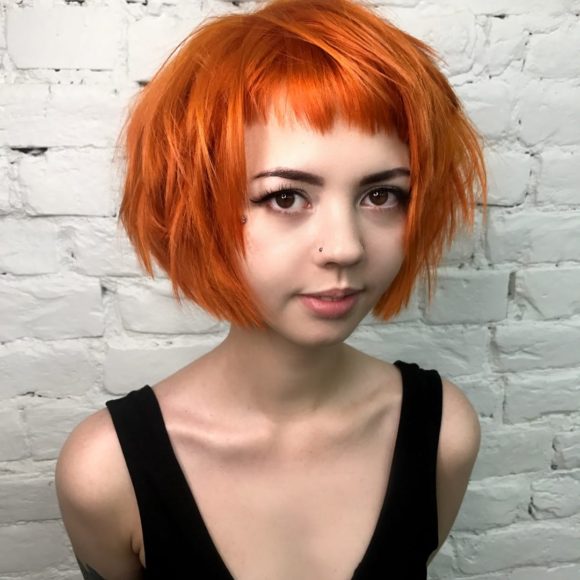 Short Choppy Bob with Micro Bangs and Messy Straight Texture on Fiery Sunset Orange Colored Hair Short Summer Hairstyle