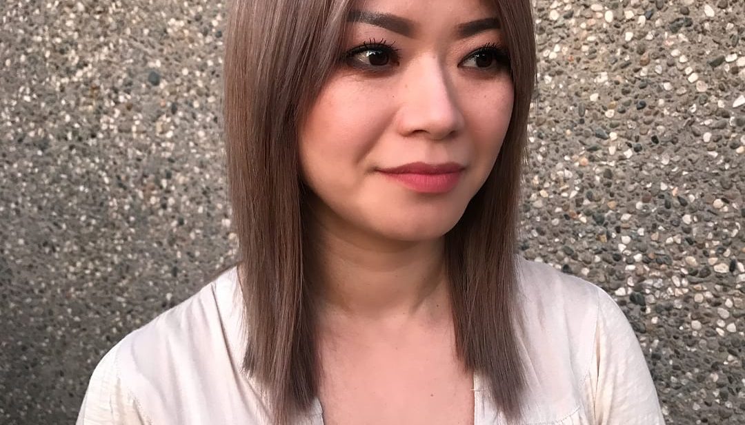 Straight Smoky Rose Gold Colored Lob with Blunt Lines and Curtain Bangs Medium Length Hairstyle
