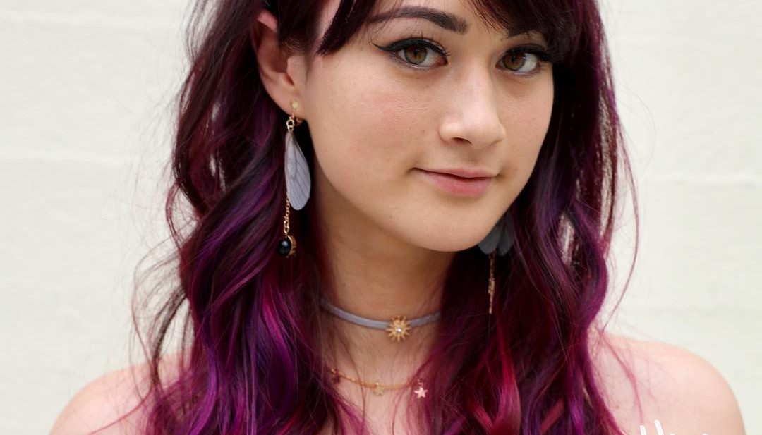 Wavy Mid-Length Layered Cut with Brow Skimming Bangs and Brunette to Magenta Hand Painted Hair Color Medium Length Summer Hairstyle