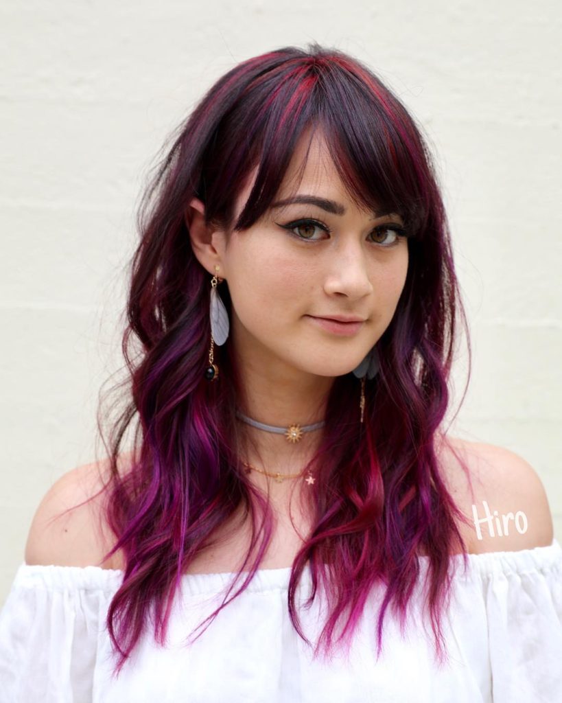 Wavy Mid-Length Layered Cut with Brow Skimming Bangs and Brunette to Magenta Hand Painted Hair Color Medium Length Summer Hairstyle